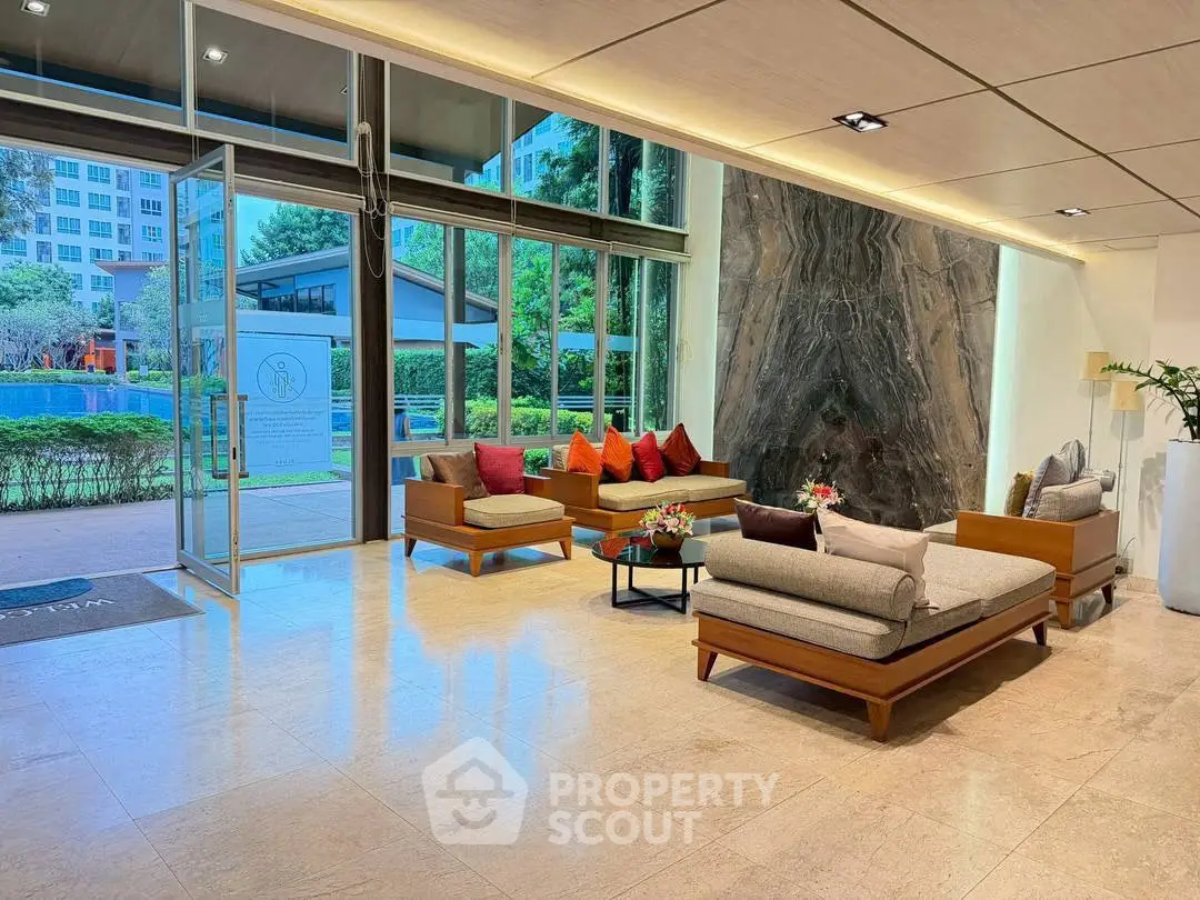 Elegant building entrance with modern seating and large glass doors, offering a welcoming ambiance.