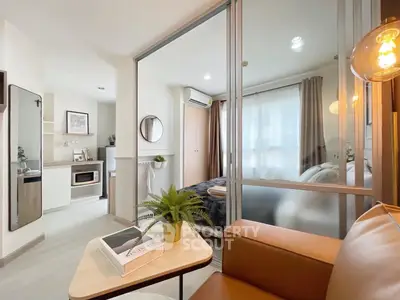 Modern studio apartment with glass partition, cozy living area, and stylish decor.