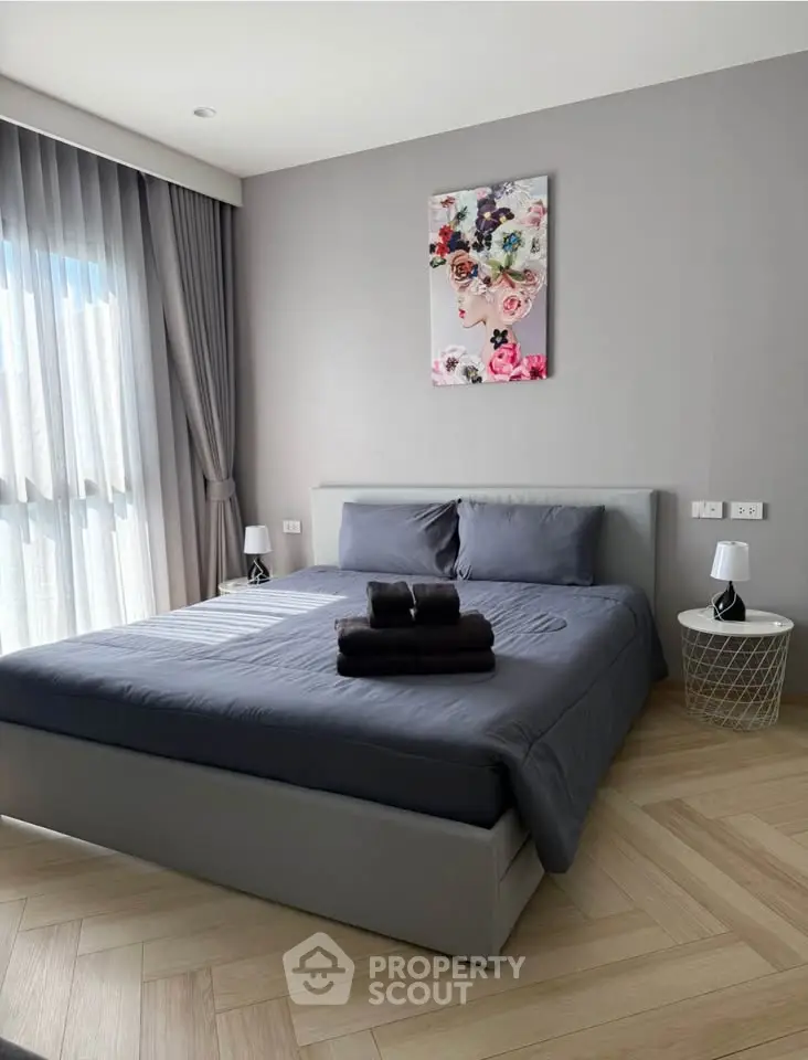 Modern bedroom with elegant decor and natural light, featuring a cozy bed and stylish furnishings.