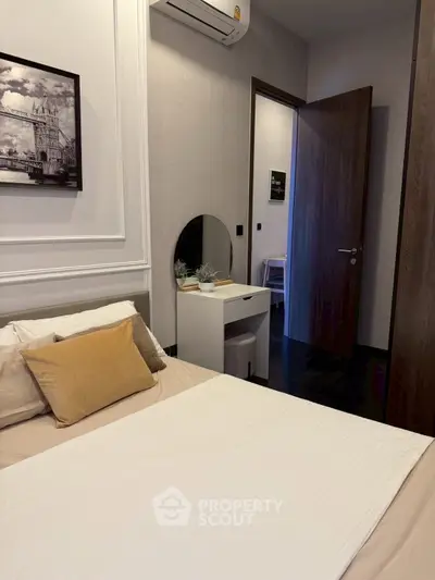 Cozy bedroom with modern decor and air conditioning, featuring a stylish wall art and a small vanity.