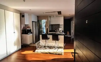 Modern kitchen with sleek design, featuring an island and stylish bar stools.