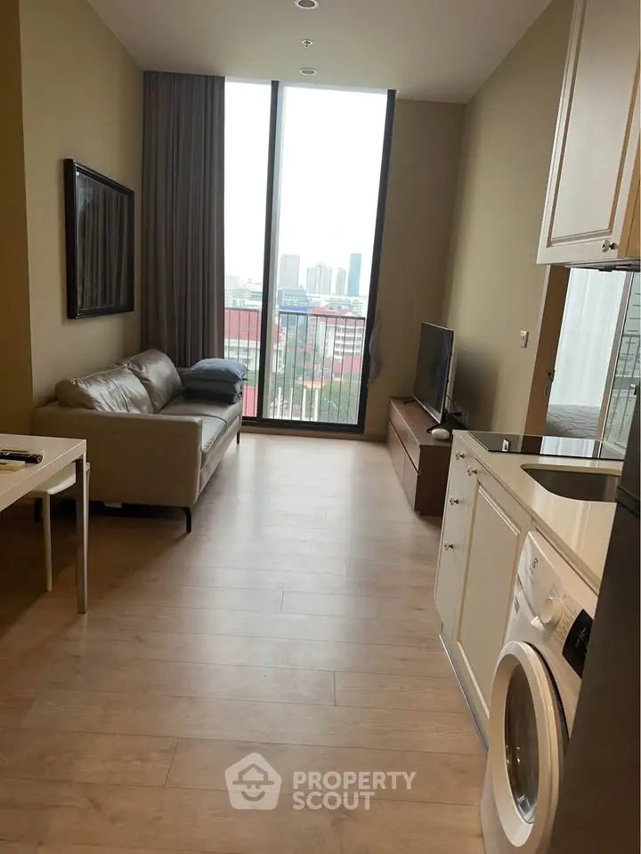 Modern living room with city view, featuring a cozy sofa, TV, and in-unit washing machine.