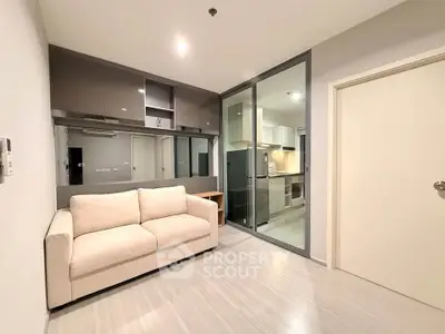 Modern living room with sleek kitchen and cozy sofa in open layout apartment.