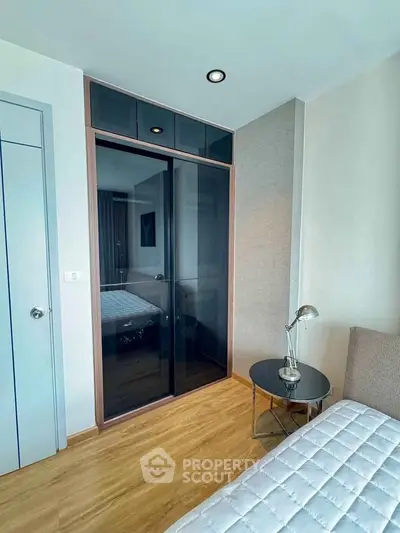 Modern bedroom with sleek glass wardrobe and cozy decor