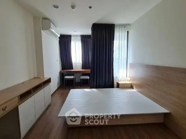 Spacious bedroom with modern design and large windows for natural light.
