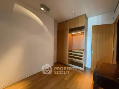Spacious room with wooden flooring and built-in closet, perfect for storage solutions.
