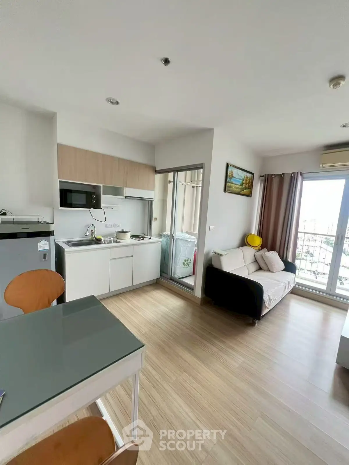Modern open-layout living room with kitchen and balcony in a stylish apartment.