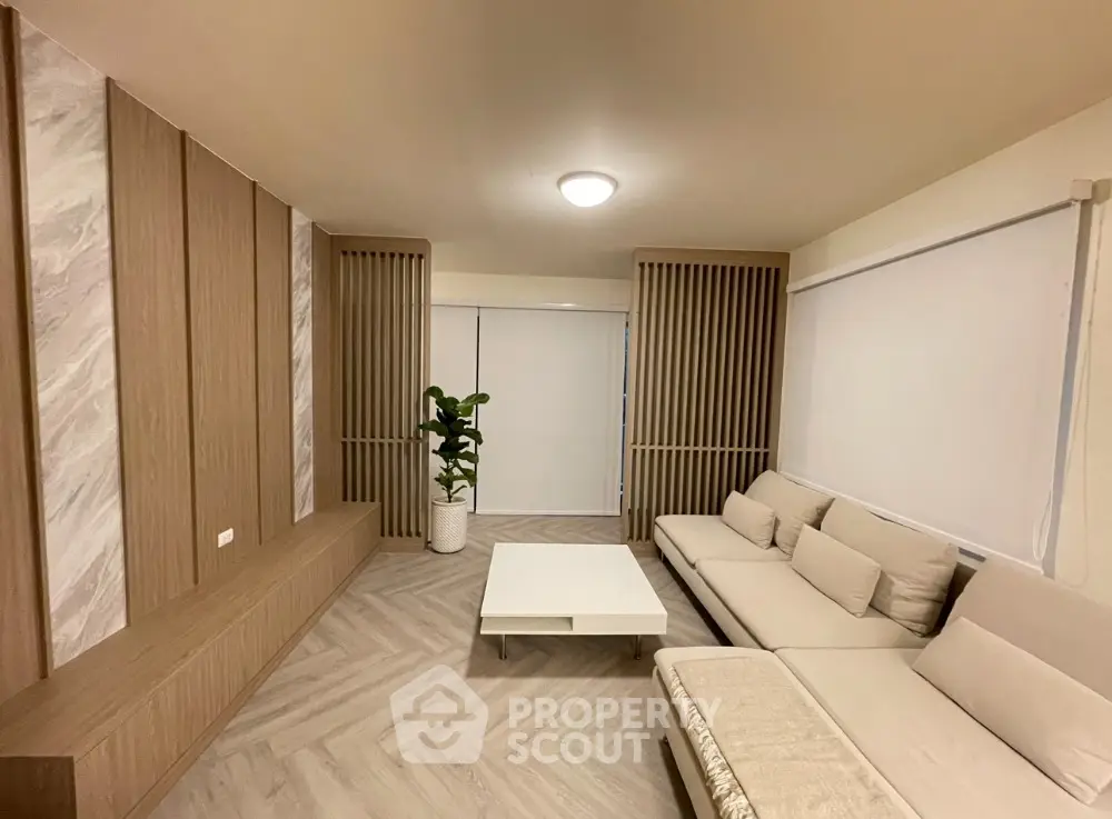 Modern living room with stylish wood paneling and cozy beige sofa