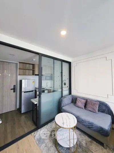 Modern living room with cozy sofa, stylish decor, and open kitchen layout in a chic apartment.