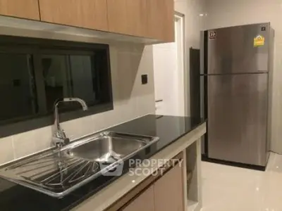 Modern kitchen with sleek design featuring stainless steel fridge and elegant cabinetry.