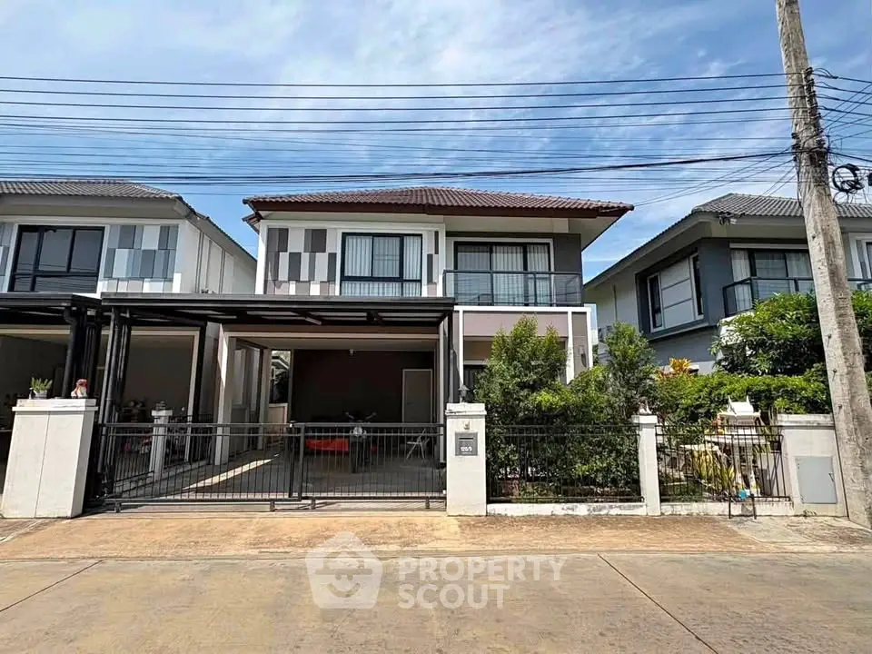 Modern two-story house with gated driveway and landscaped front yard in suburban neighborhood.