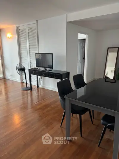 Spacious living room with modern furniture and wooden flooring, perfect for entertaining guests.
