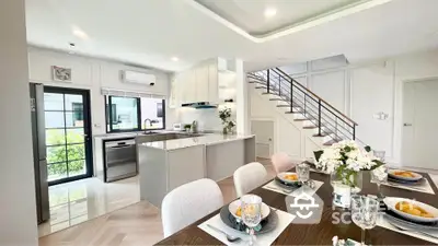 Modern open-plan kitchen and dining area with elegant decor and natural light.