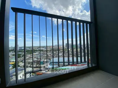 Stunning cityscape view from a high-rise balcony with clear blue skies.