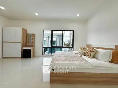 Spacious modern bedroom with large window and stylish decor