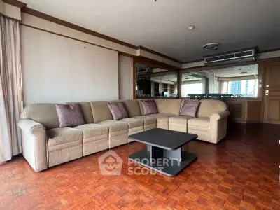 Spacious living room with elegant sectional sofa and wooden flooring