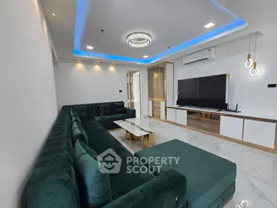 Luxurious modern living room with elegant green sectional sofa and sleek entertainment center.