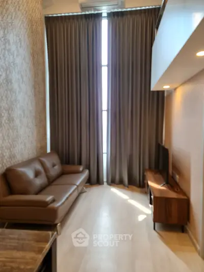 Modern living room with brown leather sofa and large window curtains