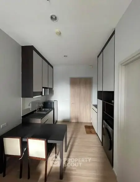 Modern kitchen with sleek cabinetry and dining area in a stylish apartment.