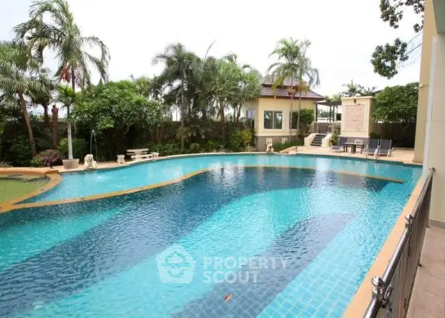 Luxurious outdoor pool surrounded by lush greenery and elegant architecture, perfect for relaxation and entertainment.