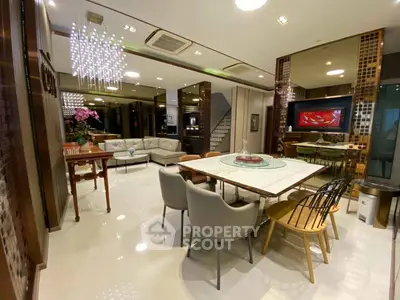 Luxurious open-plan living and dining area with modern decor and elegant lighting