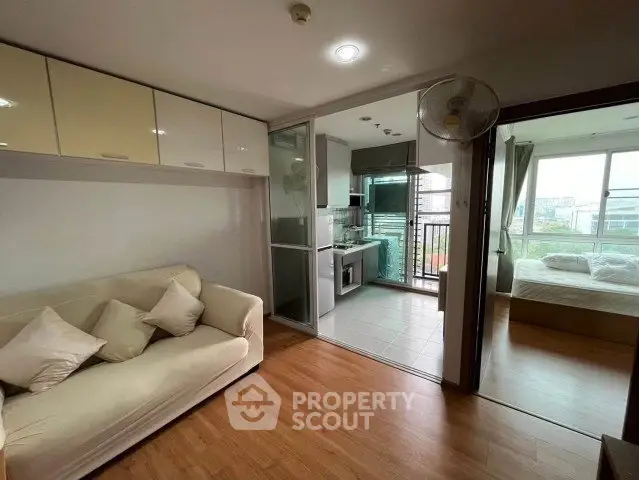 Modern apartment with open layout, cozy living room, and bright bedroom, featuring sleek kitchen design.