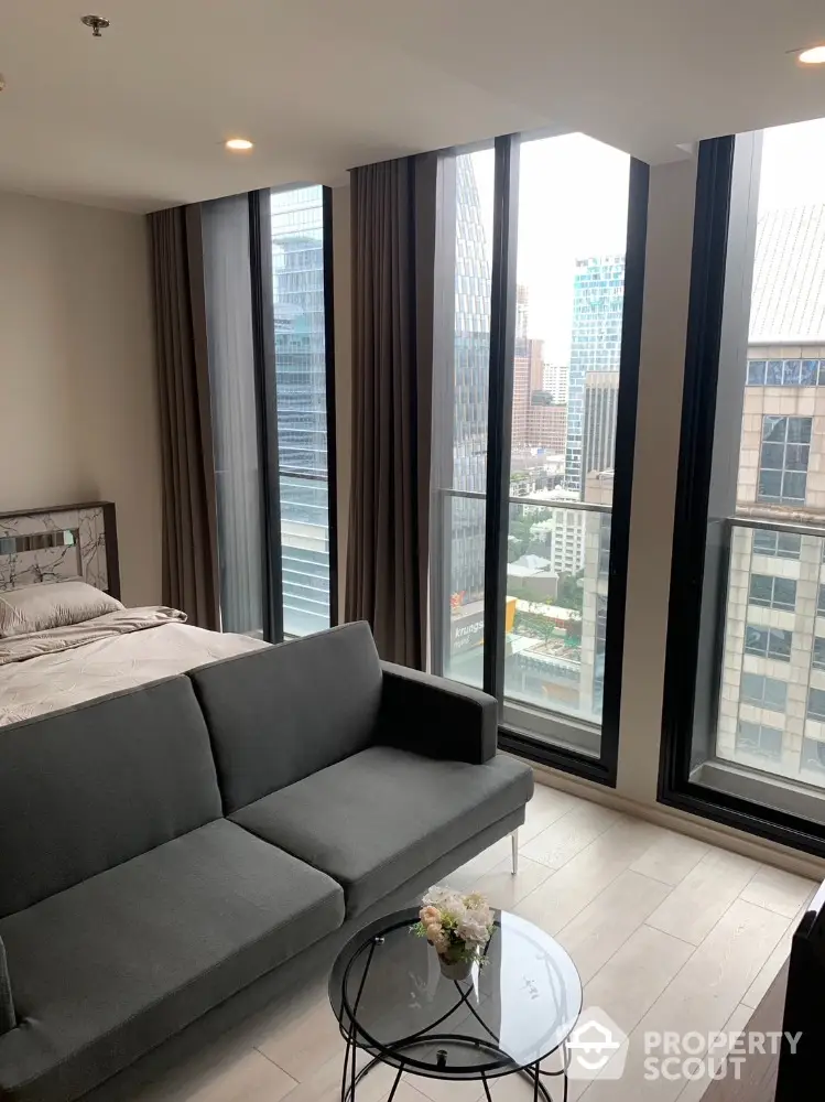 Modern living room with city view, floor-to-ceiling windows, and stylish furniture