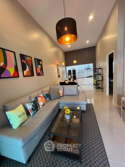 Stylish modern living room with high ceilings and open layout to kitchen, featuring chic decor and cozy seating.