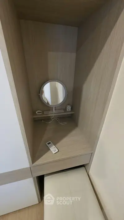 Cozy study nook with built-in desk and mirror, perfect for small spaces.