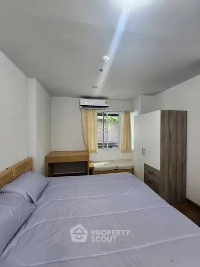 Cozy bedroom with modern furnishings and natural light, featuring a comfortable bed and ample storage space.