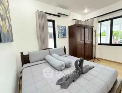 Cozy bedroom with elegant decor and ample natural light, featuring a stylish wardrobe and air conditioning.
