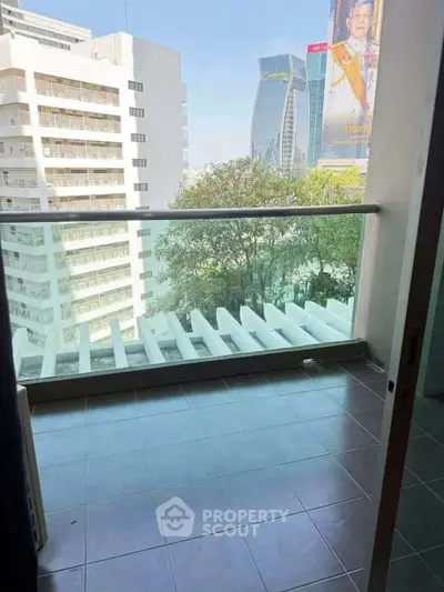 Modern balcony with city view, featuring sleek glass railing and tiled flooring, perfect for urban living.