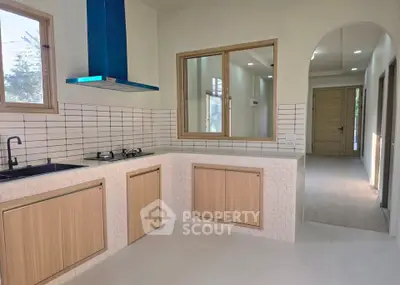 Modern kitchen with sleek cabinetry and gas stove in a bright, airy home interior.