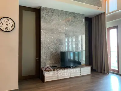 Luxurious living room with modern TV setup and elegant marble wall design.