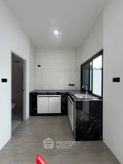 Modern kitchen with sleek black marble countertops and white subway tile backsplash