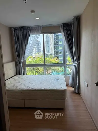 Bright bedroom with large window offering city view and natural light