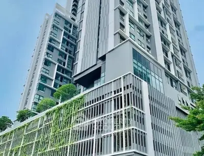 Modern high-rise building with lush vertical garden and sleek architectural design.