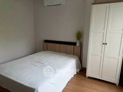 Cozy bedroom with white wardrobe and air conditioning, perfect for relaxation.