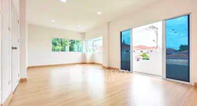 Spacious empty room with large windows and balcony access, perfect for customization.