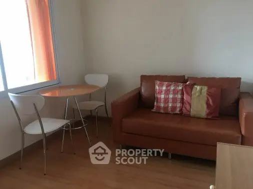 Cozy living room with modern sofa and dining set, perfect for small spaces.