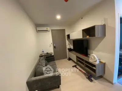 Modern living room with sleek furniture and wall-mounted TV in a cozy apartment.