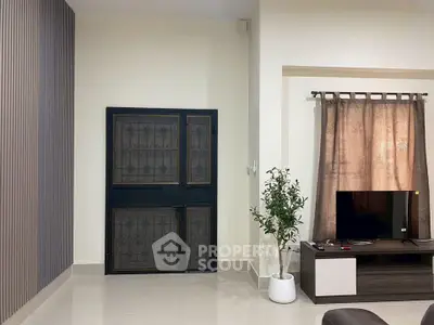 Modern living room with sleek TV stand and potted plant, featuring a secure metal door and elegant curtains.