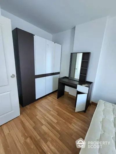 Modern bedroom with sleek wardrobe and stylish vanity on wooden flooring