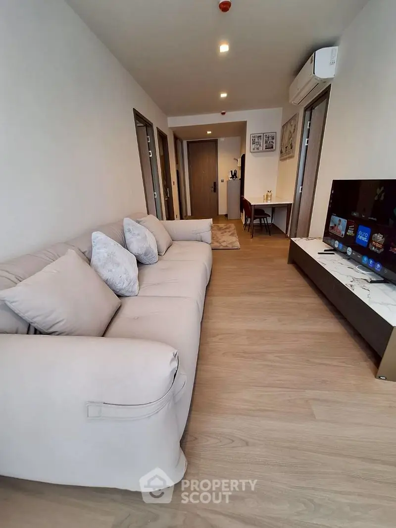 Modern living room with cozy sofa and sleek TV setup in a stylish apartment.