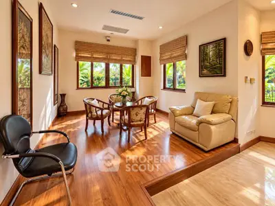 Elegant living room with wooden flooring and stylish furniture, featuring large windows with lush garden views.