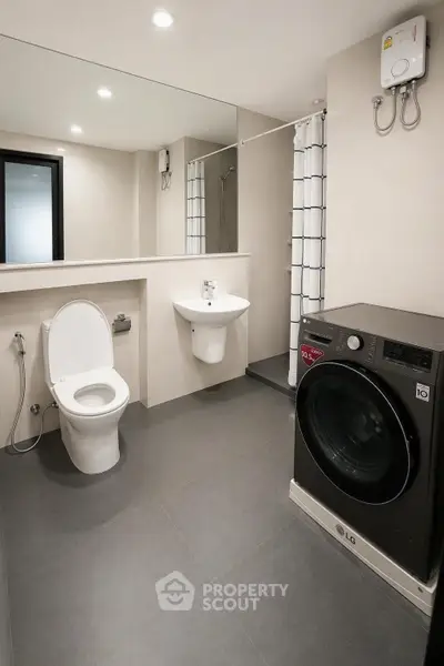 Modern bathroom with washing machine and sleek fixtures in a contemporary apartment.