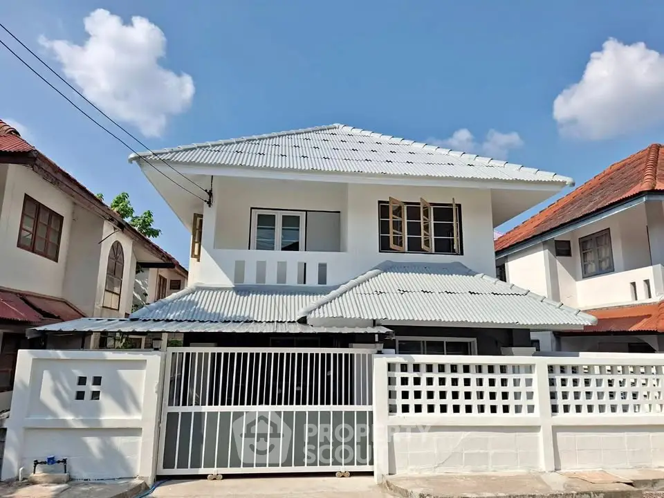 Charming two-story house with modern design and gated entrance in a serene neighborhood.