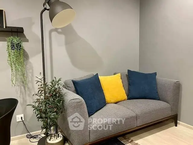 Cozy living room corner with modern gray sofa and stylish floor lamp.