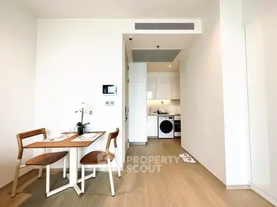 Modern open-plan kitchen and dining area with wooden flooring and sleek appliances.