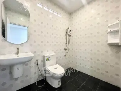 Modern bathroom with sleek fixtures and tiled walls, featuring a shower and toilet in a minimalist design.
